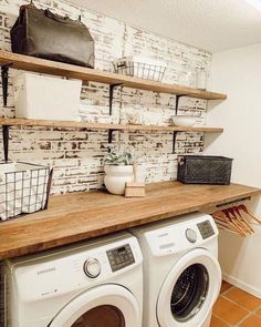 a washer and dryer are sitting on the counter in front of a brick wall