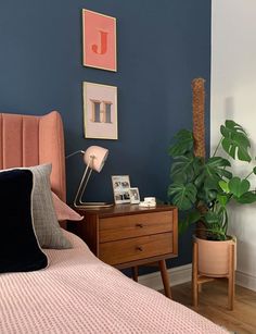 a bed room with a neatly made bed and a plant