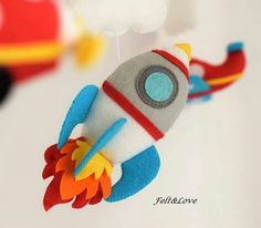 a stuffed toy rocket ship hanging from the ceiling