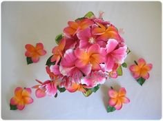 pink and orange flowers are arranged on a white surface