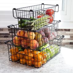 three metal baskets filled with fruit on top of a counter