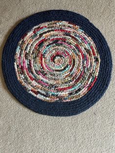 a blue rug with multicolored circles on the floor next to a white carpet