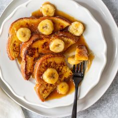 some bananas and syrup on a plate with a fork