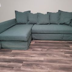 a large green couch sitting on top of a hard wood floor