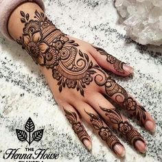 a woman's hand with henna tattoos on it