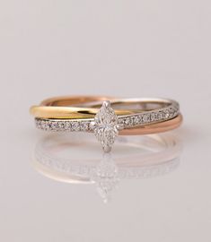 two gold and white diamond wedding rings on a reflective surface