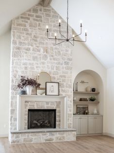 a living room with a fire place and a chandelier hanging from the ceiling