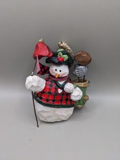 a snowman figurine holding a red and black umbrella