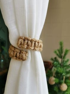 two crocheted rings are attached to the curtain in front of a christmas tree