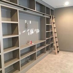 an empty room with shelves and ladders in it