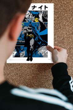 a person holding up a poster with batman on it