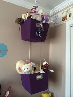 two hanging baskets filled with stuffed animals on top of a wall next to a door