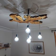 a chandelier made out of wood and light bulbs hanging from it's ceiling