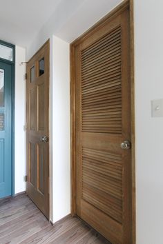 two wooden doors are open in an empty room with wood flooring and white walls