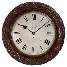 an ornate wooden clock with roman numerals on the face and hands is shown