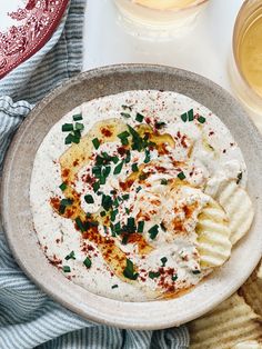 a bowl filled with hummus and crackers on top of a table