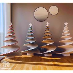 three wooden christmas trees sitting next to each other on top of a hard wood floor