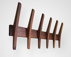 a wooden coat rack with five hooks on it