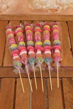 several lollipops are wrapped in cellophane and sitting on a wooden table