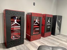 three red and black boxes sitting on top of a hard wood floor