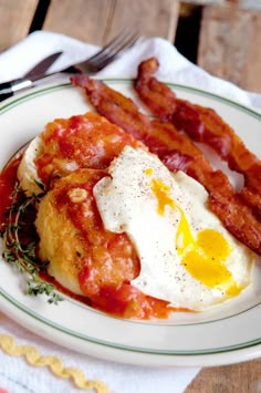 an egg and bacon breakfast on a white plate