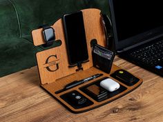 an open laptop computer sitting on top of a wooden desk next to other electronic devices