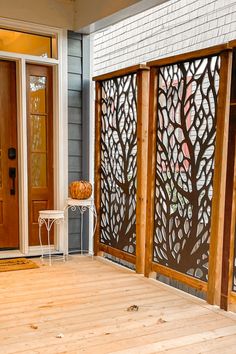 a wooden porch with an iron screen on the side and a white chair in front