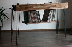 an old record player console table with hairpin legs and some vinyl records on it