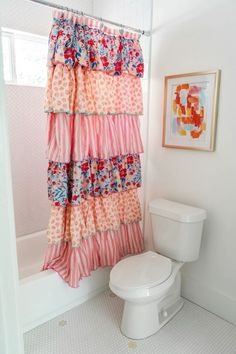 a white toilet sitting next to a shower curtain