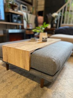 a wooden table sitting on top of a carpeted floor next to a couch and coffee table