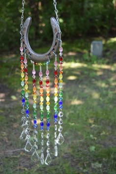 an old horseshoe hanging from a chain with beads and chains attached to the outside of it