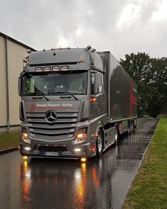 a semi truck driving down the road in the rain