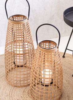 two wicker lanterns sitting on top of a rug