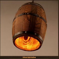 a wooden barrel hanging from the ceiling with an orange light in it's center