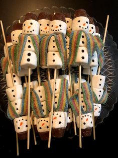 marshmallows with frosting and snowmen on them sitting on a plate