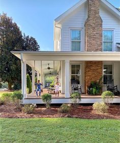 two people standing on the front porch of a house