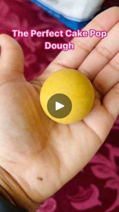 a person holding a yellow cake pop in their hand with the text, the perfect cake pop dough