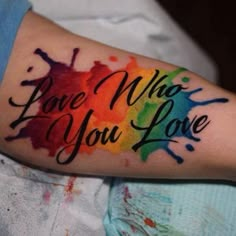 a colorful tattoo with the words love what you love painted on it's arm