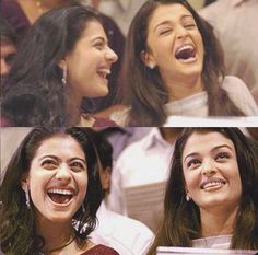 two women laughing while sitting next to each other in front of a group of people