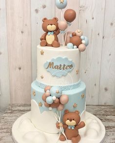 a three tiered cake decorated with teddy bears and balloons