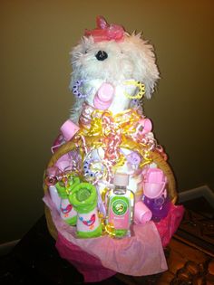 a teddy bear sitting on top of a basket filled with baby items