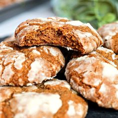 a pile of cookies sitting on top of a black plate covered in powdered sugar