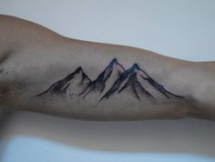 a man with a mountain tattoo on his arm