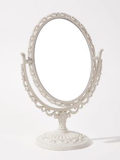 an ornate white vanity mirror sitting on top of a table