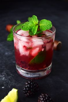 a glass filled with ice and fruit on top of a table