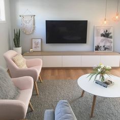 a living room with two couches and a television on the wall in front of it