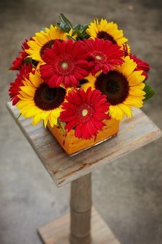 a vase filled with red and yellow flowers