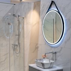 a bathroom with a sink, mirror and stand up shower stall in it's corner