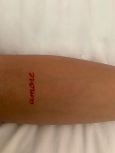 a person laying in bed with a tattoo on their arm and the word love written on it