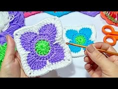 someone is crocheting flowers with yarn on the table